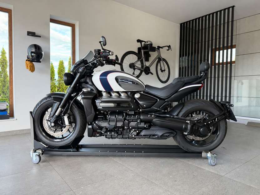 Unbranded motorcycle on a wheeled parking platform in a garage